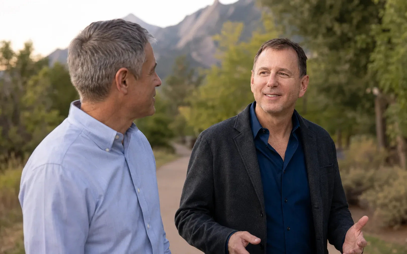 Peter Fabish and John Hoelle talking on a path with the Flatirons behind them
